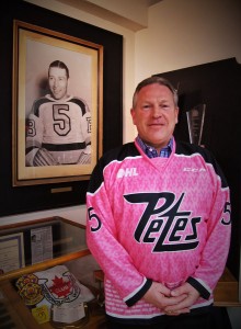 Greg Theberge poses with a portrait of his grandfather, Aubrey (Dit) Clapper before the 2016 Pink in the Rink game.